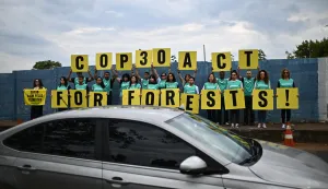 epa12451222 Greenpeace environmental activists hold signs before the opening session of the PRE-COP30 meeting at the International Convention Center in Brasilia, Brazil, 13 October 2025. during the meeting, the Brazilian presidency of COP30 urged the world to take concrete action against global warming. EPA/ANDRE BORGES