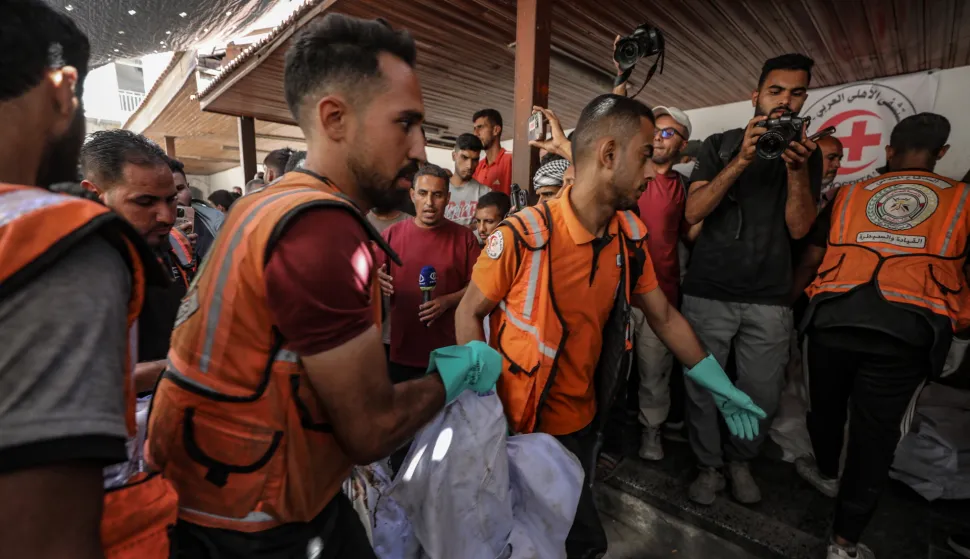 epa12462102 Palestinian civil defense workers carry the body of a member of the Abu Shaban family at Al Ahli Baptist Hospital in Gaza City, 18 October 2025. At least eleven members of the Abu Shaban family were killed a day earlier when their car was hit by an Israeli army strike in the Al Zaitun neighbourhood, east of Gaza City. EPA/MOHAMMED SABER