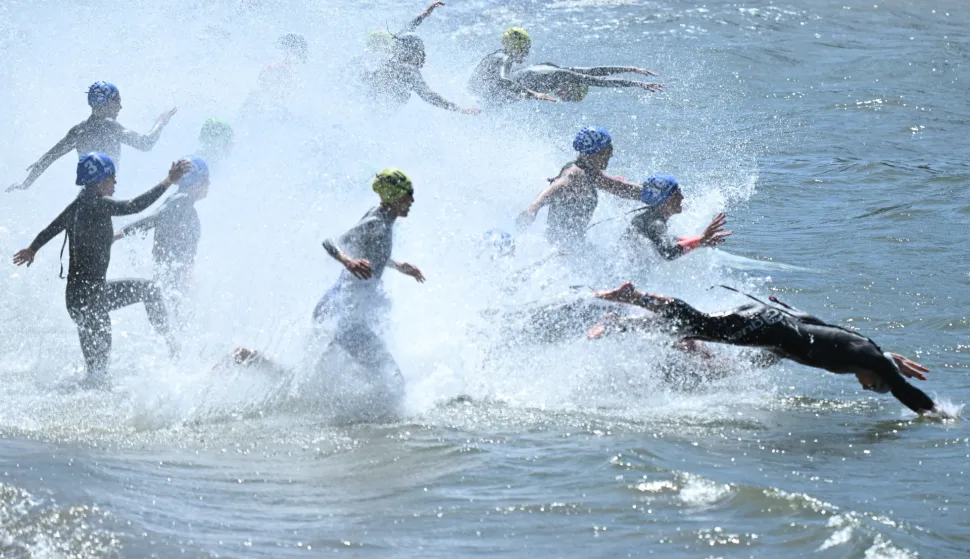 epa12463695 Competitors run into the water during the start of the Elite Women's final at the World Triathlon Championships in Wollongong, Australia, 19 October 2025. EPA/DEAN LEWINS NO ARCHIVING, EDITORIAL USE ONLY AUSTRALIA AND NEW ZEALAND OUT