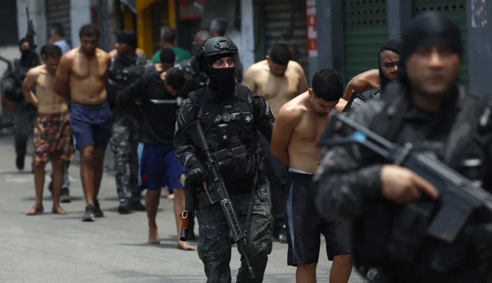 epa12487894 Rio de Janeiro Police officers guard a group of people during an operation in Rio de Janeiro, Brazil, 28 October 2025. At least twenty people were killed and fifty were arrested during a major police operation against Comando Vermelho, one of the most powerful organized crime gangs in Rio de Janeiro. EPA/ANTONIO LACERDA