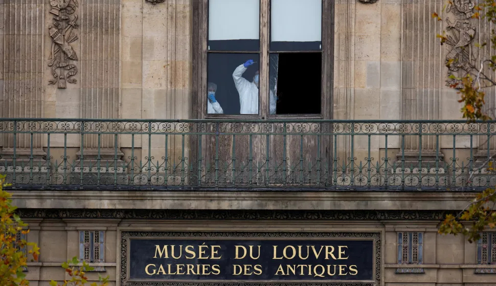 FILE PHOTO: Members of a forensic team inspect a window believed to have been used in what the French Interior Ministry said was a robbery at the Louvre museum during which jewellery was stolen, in Paris, France, October 19, 2025. REUTERS/Gonzalo Fuentes/File Photo Photo: GONZALO FUENTES/REUTERS