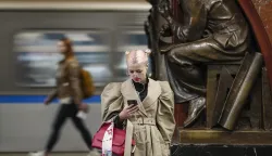 epaselect epa10580283 A woman looks at her phone while waiting for a train at a metro station in Moscow, Russia, 19 April 2023. EPA/YURI KOCHETKOV