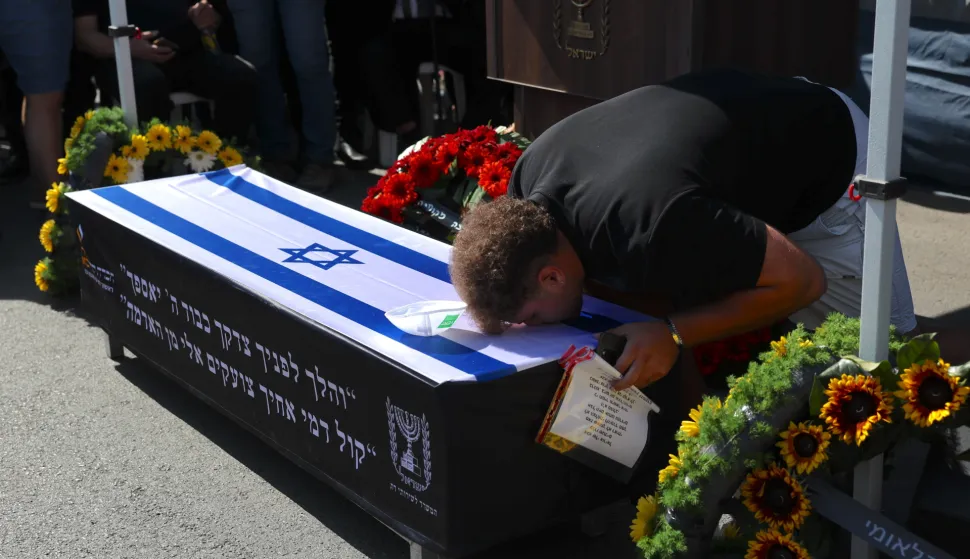 epa12464318 A person mourns on the coffin of late Israeli hostage Uriel Baruch during his funeral procession in Jerusalem, 19 October 2025. Baruch was kidnapped by Hamas on 07 October 2023 at the Nova music festival and killed in captivity. His body was returned as part of a ceasefire agreement between Israel and Hamas. EPA/ABIR SULTAN