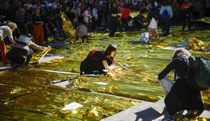 epa12490205 People set 229 thermal blankets on the Plaza de la Virgen square during an act in tribute to the victims of the DANA floods on the the first anniversary of the tragedy, in Valencia, Spain, 29 October 2025. Floods triggered by the DANA (high-altitude isolated depression) weather phenomenon that hit the east of Spain on 29 October 2024, devastated several towns in Valencia and neighboring provinces, leaving 229 people dead and causing damages exceeding 18 billion euros. EPA/BIEL ALINO