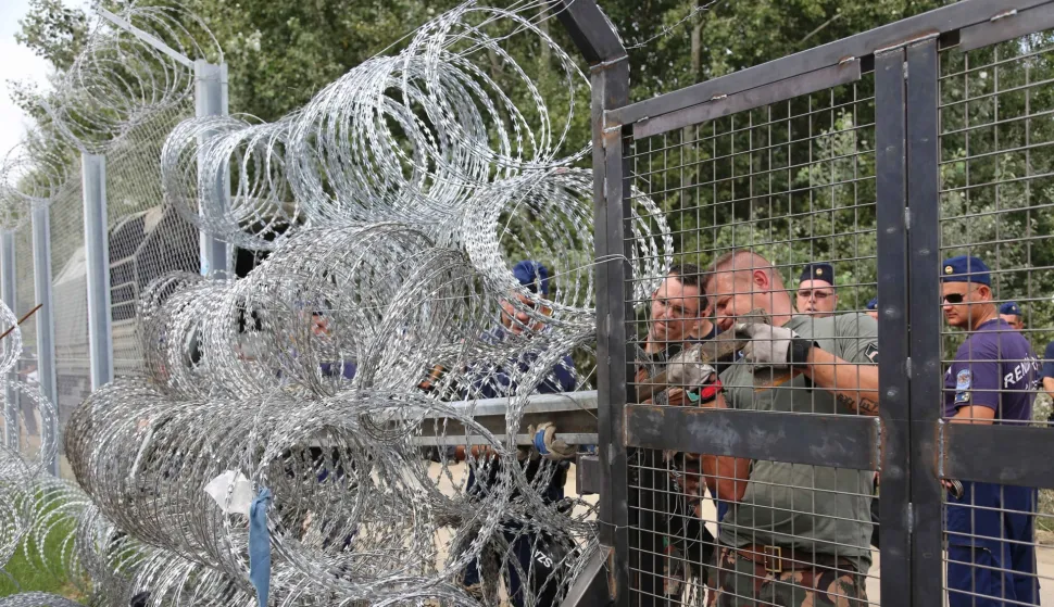 SERBIA-HORGOS-BORDER-HUNGARY-REFUGEES AND MIGRANTS(150916) -- HORGOS(SERBIA), Sept. 16, 2015 (Xinhua) -- Hungarian policemen repair and reinforce barbed wire fence at the border crossing between Hungary and Serbia near Horgos, north of Serbia, on Sept. 16, 2015. The Serbian Foreign Ministry on Wednesday published an official note received from Hungary revealing two border crossings between the two countries will be closed for 30 days due to the escalating refugee crisis. (Xinhua/Wang Huijuan)Wang Huijuan Photo: XINHUA/PIXSELL