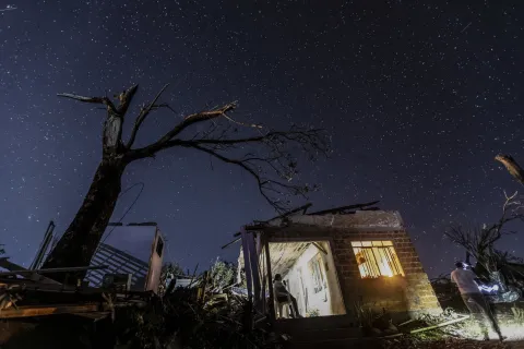 epa12513274 A woman waits seated in her home, which was partially destroyed by a tornado, in Rio Bonito do Igua?u, Brazil, 08 November 2025. Authorities in the southern Brazilian state of Paran? declared a state of public calamity in the municipalities hit on by an unprecedented tornado that left at least people six dead and 750 injured. EPA/Sergio Ranalli