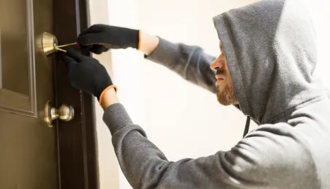 Profile view of a man with a hoodie trying to pick a lock in a house and forcing his entrylopov kradja provala krađa kradljivac kriminal provalnik obijanje brave ilustracija freepik