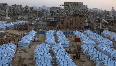 epa12533945 Displaced Palestinians walk amid makeshift shelters erected beside the ruins of destroyed buildings in northern Gaza City, Gaza Strip, 18 November 2025, amid a ceasefire between Israel and Hamas. Around 1.9 million people in Gaza, nearly 90 percent of the population, have been displaced since the Israel-Hamas conflict began in October 2023, according to the UN. EPA/MOHAMMED SABER