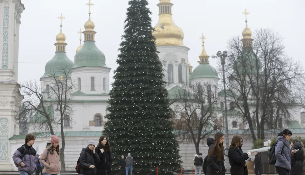 epa12562105 People walk past a Christmas tree near the Saint Sophia Cathedral in Kyiv, Ukraine, 01 December 2025, amid the ongoing Russian invasion. For the third year, Ukraine will celebrate Christmas on 25 December, according to the Gregorian calendar. The Ukrainian president signed a law in 2023 to move the official Christmas holiday to 25 December, departing from the Orthodox Church's tradition of celebrating Christmas on 07 January. EPA/SERGEY DOLZHENKO