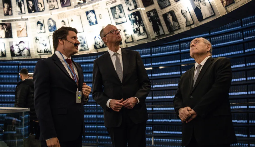 epa12576407 Dani Dayan (R), chairman of the Yad Vashem Holocaust Memorial Museum, stands with German Chancellor Friedrich Merz at the museum's Hall of Names in Jerusalem, 07 December 2025. EPA/JOHN WESSELS/POOL