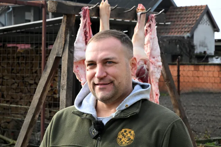 Stari Mikanovci, 08.12.2025. - Potpredsjednik Vlade i ministar poljoprivrede, &scaron;umarstva i ribarstva David Vlajčić&nbsp;u ponedjeljak, 8. prosinca 2025. godine&nbsp;sudjelovao je u tradicionalnoj svinjokolji kod Marka Ljubasa u Starim Mikanovcima (kod Vinkovaca). Na fotografiji David Vlajčić. foto HINA/ Gordan Panić/ tm