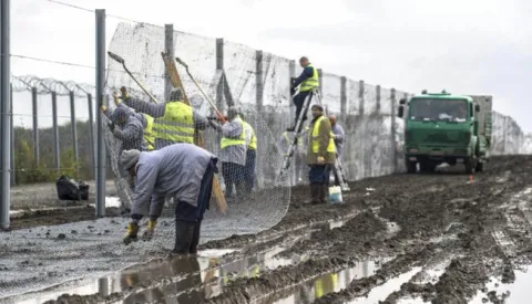 epa05606793 Hungarian convicts install an experimental section of the second line of the border fence at the Hungarian-Serbian border near the village of Gara, 213 kms south of Budapest, Hungary 28 October 2016. The 10.3 kilometer long section is constructed between Gara and Bacsszentgyorgy to reinforce the primary fence that prevents illegal migrants using the Balkan route from entering Hungary. EPA/SANDOR UJVARI HUNGARY OUT