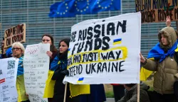epa12586971 Ukrainians hold placards during a protest demanding the use of the frozen Russian assets, on the sidelines of the Economic and Financial Affairs Council (ECOFIN) meeting in Brussels, Belgium, 12 December 2025. Belgium has been blocking an EU plan to approve a large 'reparations loan' for Ukraine backed by frozen Russian state assets, because it fears major legal and financial risks since most of those assets are held in Brussels and is demanding stronger guarantees before it will agree to let the scheme go ahead. EPA/OLIVIER HOSLET