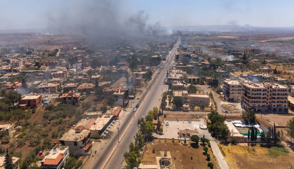 epa12245150 An aerial picture taken by drone shows smoke rising from the town of Al-Mazra'a as a result of burning houses following clashes between Bedouin tribes and local Druze factions, in the Suwayda countryside in southern Syria, on 18 July 2025. Several Bedouin tribes declared a general mobilization to fight against Druze factions after local Druze factions displaced Bedouin families and killed dozens of them. EPA/AHMAD FALLAHA