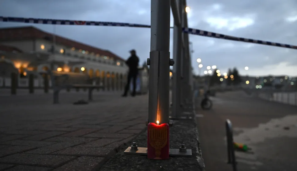 epa12592432 A candle featuring the menorah is lit at the scene of a shooting at Bondi Beach, in Sydney, New South Wales (NSW), Australia, 15 December 2025. According to Police, at least 11 people have been killed and 29 injured after a gunman EPA/DEAN LEWINS AUSTRALIA AND NEW ZEALAND OUT