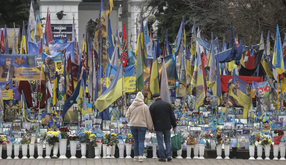 epa12594169 People walk next to a makeshift memorial dedicated to the fallen Ukrainian soldiers and international volunteers in Independence Square in Kyiv, Ukraine, 15 December 2025, amid the Russian invasion. EPA/SERGEY DOLZHENKO
