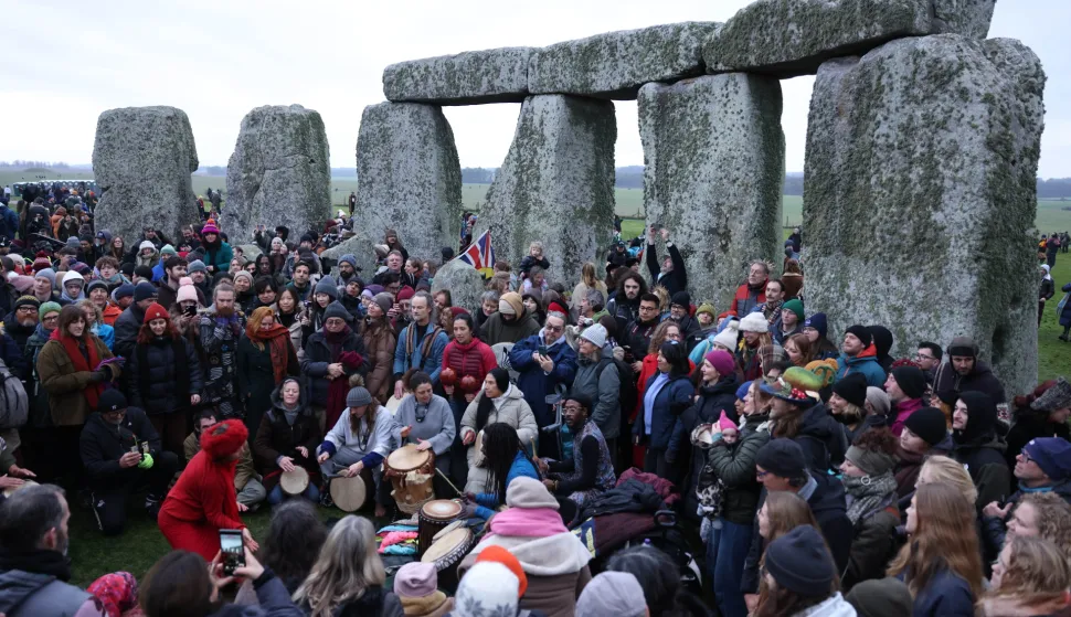epa12606778 Revellers during the Winter Solstice at Stonehenge near Amesbury, Britain, 21 December 2025. The winter solstice, also known as midwinter, marks the day with the shortest period of daylight and the longest night of the year. Stonehenge, which was constructed in 3000BC is a prehistoric megalithic structure on Salisbury Plain amid a complex of Neolithic and Bronze Age monuments. It is thought to be aligned to the sun's movement during the summer and winter solstice. EPA/NEIL HALL