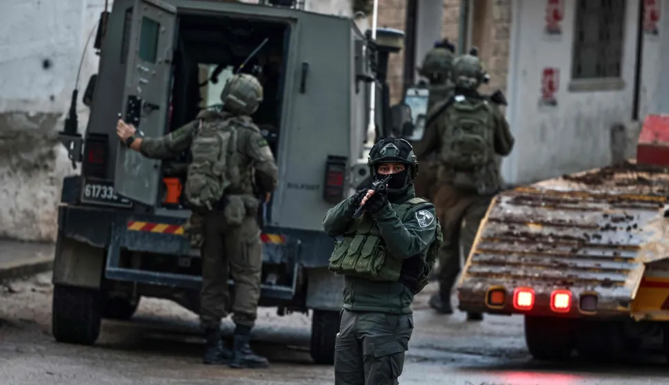 Israeli security forces secure a street as they leave the Palestinian village of Bizariya, in the occupied West Bank, where Israeli authorities demolished the house of a Palestinian man killed in July after he and another man reportedly killed an Israeli settler on the same day, on December 24, 2025. (Photo by Zain JAAFAR/AFP)