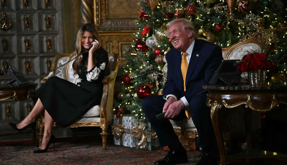 US President Donald Trump and first lady Melania Trump participate in NORAD Santa tracker phone calls, on Christmas Eve, from the Mar-a-lago club in Palm Beach, Florida, on December 24, 2025. (Photo by ANDREW CABALLERO-REYNOLDS/AFP)