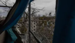 Workers clear debris from the roof of a heavily damaged residential building following a drone strike in Kyiv, on December 23, 2025, amid the Russian invasion of Ukraine. Several Ukrainian regions suffered power cuts in frigid winter weather on December 23, 2025, after Russia launched its latest deadly large-scale attack with drones and missiles, authorities said. (Photo by Roman PILIPEY/AFP)