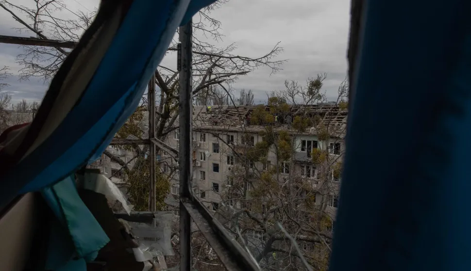 Workers clear debris from the roof of a heavily damaged residential building following a drone strike in Kyiv, on December 23, 2025, amid the Russian invasion of Ukraine. Several Ukrainian regions suffered power cuts in frigid winter weather on December 23, 2025, after Russia launched its latest deadly large-scale attack with drones and missiles, authorities said. (Photo by Roman PILIPEY/AFP)