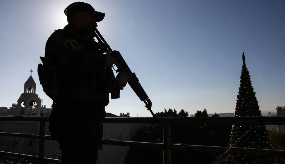 A member of the Palestinian securtiy forces stands guard on a roof overlooking Nativity Square in Bethlehem, in the Israeli-occupied West Bank, ahead of Christmas celebrations on December 24, 2025. (Photo by HAZEM BADER/AFP)