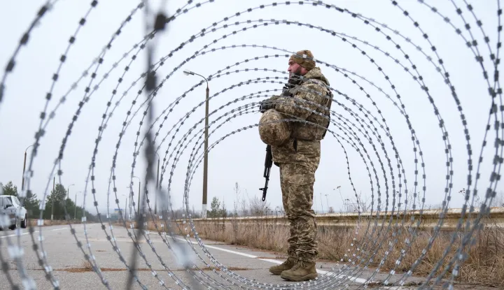 epa12602941 A member of the State Border Guard Service of Ukraine guards at a crossing point on the border with Belarus in Chernihiv Oblast, Ukraine, 18 December 2025 (issued 19 December 2025). The bridge that previously linked the borders of Ukraine and Belarus was demolished by Ukrainian forces in 2022 to obstruct the advance of Russian troops during the initial invasion. EPA/MARIA SENOVILLA