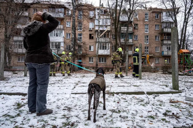 A woman with a dog looks at an apartment block in the Shevchenkivskyi district damaged by a Russian strike as rescuers respond to the incident, Kyiv, Ukraine, December 27, 2025. (Photo by Danylo Antoniuk/Ukrinform) (Photo by Ukrinform/Ukrinform/Sipa USA) Photo: UKRINFORM/SIPA USA