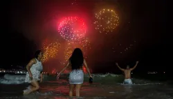 (FILES) People celebrate as they watch the traditional New Year's fireworks from the water at Copacabana Beach in Rio de Janeiro, Brazil, on January 1, 2024. Rio de Janeiro received on December 30, 2025, the title of the world?s largest New Year?s Eve celebration from the Guinness World Records, a recognition of its famous massive festivity with live music shows by the sea (Photo by TERCIO TEIXEIRA/AFP)