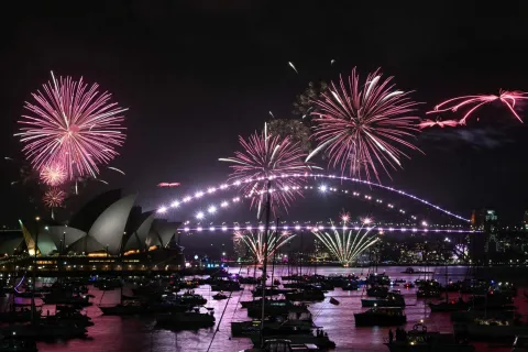 The "family fireworks" light up the Opera House and the Sydney Harbour Bridge three hours ahead of the main show at midnight in Sydney on New Year's Eve on December 31, 2025. (Photo by Saeed KHAN/AFP)