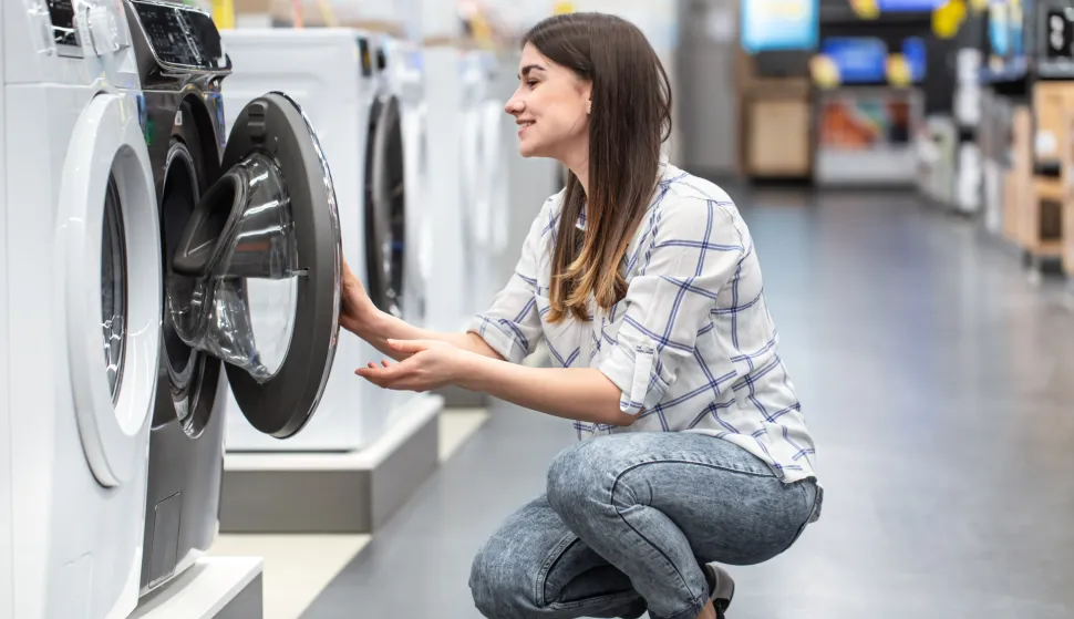 A young woman in a store chooses a washing machine.. The concept of shopping. novosti koje donose izmjene Zakona o za&scaron;titi potro&scaron;ačatrgovina prodaja gospodarstvo ekonomija trgovac ilustracija freepik