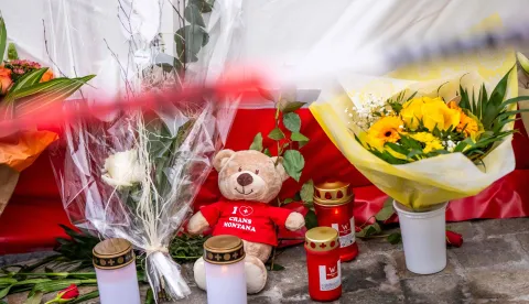 This photograph shows flowers, candles and a teddy bear laid near the site of a fire that ripped through a bar during New Year's Eve celebrations in the Alpine ski resort town of Crans-Montana killing around 40 people and injuring more than 100 others, in Crans-Montana on January 2, 2026. Investigators raced on January 2, 2026 to identify the victims of a fire that ripped through a bar in the Swiss Alps town of Crans-Montana, turning a New Year's celebration into one of the country's worst tragedies. Frederic Gisler, police commander in the Wallis canton in southwestern Switzerland, told reporters that authorities had counted "around 40 people who have died and around 115 injured, most of them seriously". (Photo by MAXIME SCHMID/AFP)
