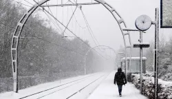 A train passenger walks on a snow-covered platform along a railway in Hollandsche Rading, The Netherlands on January 5, 2026 as train traffic is affected by the wintry weather. (Photo by Sander Koning/ANP/AFP)/Netherlands OUT