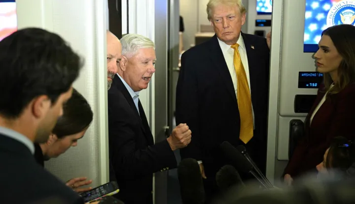 US senator Lindsey Graham (C), Republican of South Carolina, flanked by President Donald Trump (R) and the Secretary of Commerce Howard Lutnick, speaks with reporters aboard Air Force One on their way back to Washington, DC, on January 4, 2026. President Trump is returning to DC after spending the holidays at his Mar-a-Lago residence in Palm Beach, Florida. (Photo by Jim WATSON/AFP)