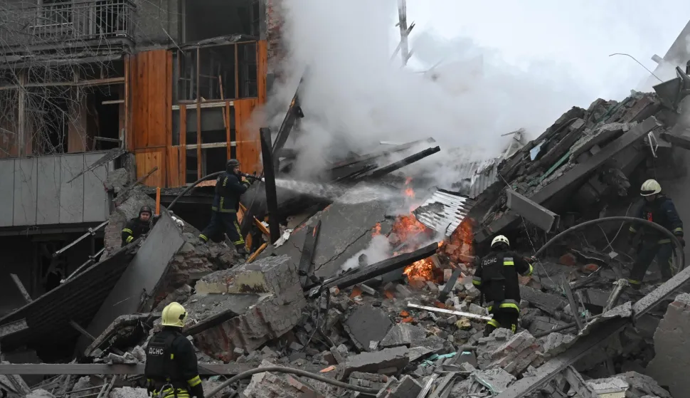 Ukrainian firefighters extinguish a fire in a residential building following a Russian air strike in Kharkiv on January 2, 2026, amid the Russian invasion of Ukraine. (Photo by SERGEY BOBOK/AFP)