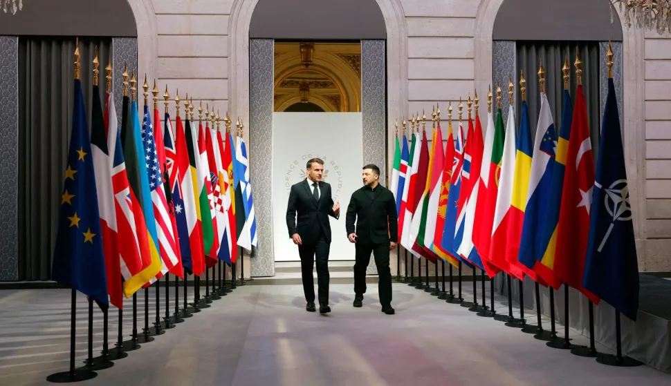 France's President Emmanuel Macron (L) and Ukraine's President Volodymyr Zelensky (R) talk as they arrive for the Coalition of the Willing meeting in Paris, at the Elysee Palace on January 6, 2026. The summit of the group of Ukraine supporters dubbed the "Coalition of the Willing" is the latest of several meetings planned for the new year as diplomatic efforts to end Europe's deadliest conflict since World War II have gained pace in recent weeks. (Photo by Yoan VALAT/POOL/AFP)