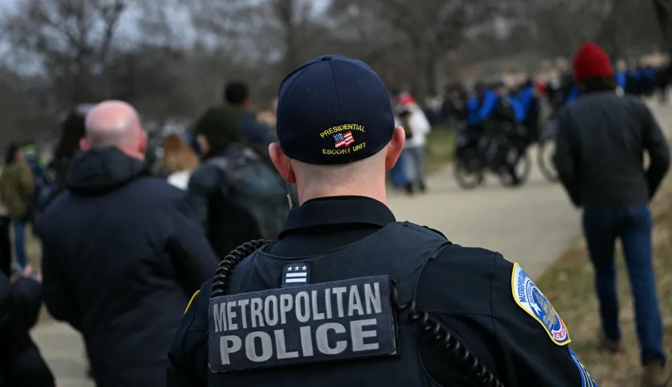 Police look on as people march to the US Capitol in a rally promoted by right-wing activists on the fifth anniversary of the January 6 riots in Washington, DC, on January 6, 2026. Washington on Tuesday marks five years since a mob overran the US Capitol, with rioters pardoned by Donald Trump retracing their steps even as Democrats revive hearings to hold the president accountable. The anniversary highlights a nation divided between irreconcilable accounts of an attack that reshaped American politics -- one supported by official findings of a violent bid to overturn an election, the other portraying it as a protest unjustly criminalized. (Photo by Brendan SMIALOWSKI/AFP)