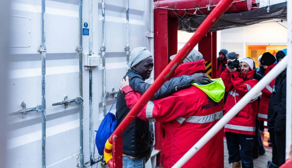 A migrant cries as he bids farewell to crew members of the rescue ship "Ocean Viking" operated by the NGO SOS Mediterranee, while disembarking at the port of Savona, northwestern Italy, on January 5, 2026. 33 migrants were saved by crew members of the rescue ship "Ocean Viking" operated by the NGO SOS Mediterranee on December 31, 2025. They had been stranded on the oil tanker the "Maridive 703" for 5 days in the joint search zone between Malta and Tunisia in international Mediterranean waters. (Photo by Sameer Al-DOUMY/AFP)