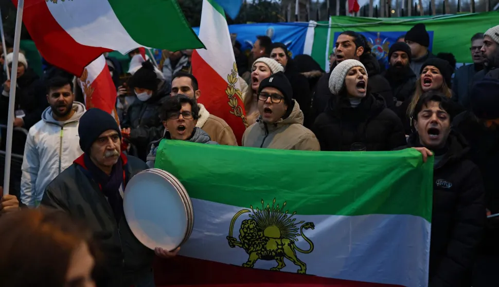 Anti-Iranian regime protesters hold the Iranian flag before the 1979 revolution with the Lion and Sun emblems during a gathering outside the Iranian Embassy, central London, on January 9, 2026. Iran FM says US, Israel 'directly intervening' in protests. Iran's foreign minister accused the United States and Israel on Friday of fuelling a growing protest movement in the country, while dismissing the possibility of direct foreign military intervention after US warnings over crackdowns on demonstrators. (Photo by Henry NICHOLLS/AFP)