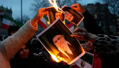 Protestors burn images of Ayatollah Ali Khamenei during a rally held in Solidarity with Iran's Uprising, organised by The national Council of Resistance of Iran, on Whitehall in central London on January 11, 2026, to protest against the Iranian regime's crackdown on internet access and "recognise their right to self-defence against the regime's forces". At least 192 people have been killed in two weeks of protests against the government and economic strain in Iran, a rights group said on Sunday, in a sharp rise from an earlier death toll of 51. (Photo by CARLOS JASSO/AFP)