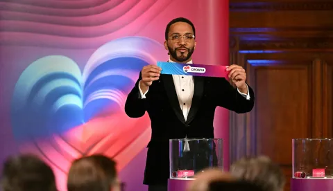 Moderator Austrian singer Cesar Sampson holds a draw for Croatia during the draw session for the two semi-final events of the Eurovision Song Contest 2026 on stage at the Vienna?s city hall in Vienna, Austria, on January 12, 2026. Vienna hosts the Eurovision Song Contest 2026 on May 12-14. (Photo by Joe Klamar/AFP)