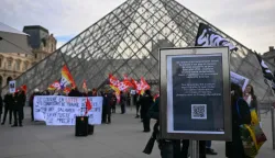 (FILES) A notice informs members of the public of the closure of the Louvre Museum as members of the French CGT union protest outside the entrance as museum workers voted to go on strike against increasingly deteriorating working conditions and the declining visitor experience at the world famous museum, in Paris on December 15, 2025. The Louvre museum was forced to close on January 12, 2026 after its staff, who have been on strike since mid-December in a bid to secure better working conditions, decided to continue their action, AFP learned from the museum and trade unions. (Photo by Blanca CRUZ/AFP)