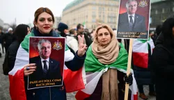 13 January 2026, Berlin: "Pahlavi will come back" is written on a sign with the image of Reza Pahlavi, son of the last Shah of Iran, during a demonstration in support of the nationwide mass protests against the government in Iran on Paris Square. Photo: Sebastian Christoph Gollnow/dpa Photo: Sebastian Christoph Gollnow/DPA