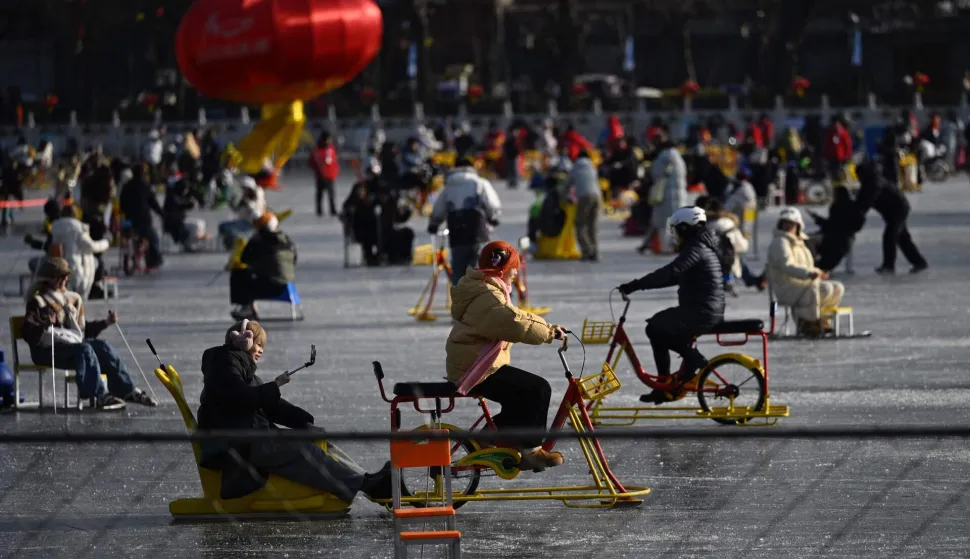 People ride ice bicycles on a frozen lake in Beijing on January 13, 2026. (Photo by WANG Zhao/AFP)