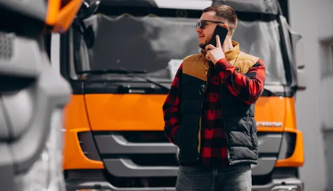 Handsome man truck driver standing by the truck