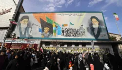 People walk past a banner depicting Iran?s Supreme Leader Ayatollah Ali Khamenei and late leader Ruhollah Khomeini on Enghelab (Revolution) Square in Terhan on January 14, 2026. Iran on Januray 14 vowed fast-track trials for people arrested over a massive wave of protests, after US President Donald Trump threatened "very strong action" if the Islamic republic goes ahead with hangings. In Tehran, authorities held a funeral ceremony for over 100 members of the security forces and other "martyrs" killed in the demonstrations, which authorities have branded as "riots" while accusing protesters of waging "acts of terror". (Photo by ATTA KENARE/AFP)