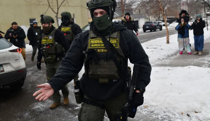 Federal agents patrol the Frogtown neighborhood while anti-ICE activists warn the community about their presence and oppose ongoing Immigration and Customs Enforcement detentions, part of heightened tensions following a federal immigration enforcement surge and recent shooting involving an ICE officer in St. Paul, Minnesota, on January 16, 2026. US President Donald Trump said Friday there was no immediate need to invoke the Insurrection Act over protests against immigration raids in Minnesota, a day after threatening to use the law. Trump had threatened the drastic measure that would have allowed him to deploy the military to the northern state for law enforcement purposes in response to protests against broad-reaching immigration raids spearheaded by his administration. (Photo by Octavio JONES/AFP)