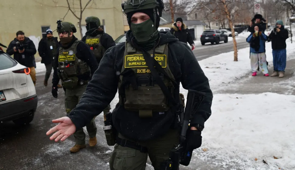 Federal agents patrol the Frogtown neighborhood while anti-ICE activists warn the community about their presence and oppose ongoing Immigration and Customs Enforcement detentions, part of heightened tensions following a federal immigration enforcement surge and recent shooting involving an ICE officer in St. Paul, Minnesota, on January 16, 2026. US President Donald Trump said Friday there was no immediate need to invoke the Insurrection Act over protests against immigration raids in Minnesota, a day after threatening to use the law. Trump had threatened the drastic measure that would have allowed him to deploy the military to the northern state for law enforcement purposes in response to protests against broad-reaching immigration raids spearheaded by his administration. (Photo by Octavio JONES/AFP)