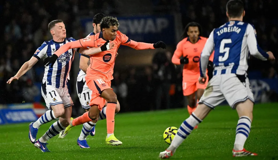 Real Sociedad's Spanish forward #17 Sergio Gomez and Barcelona's Spanish forward #10 Lamine Yamal fight for the ball during the Spanish league football match between Real Sociedad and FC Barcelona at Anoeta Stadium in San Sebastian on January 18, 2026. (Photo by ANDER GILLENEA/AFP)