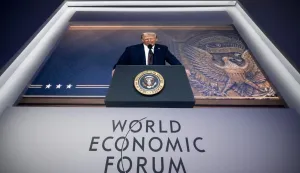 (FILES) US President Donald Trump is seen on a giant screen during his address by video conference at the World Economic Forum (WEF) annual meeting in Davos on January 23, 2025. The World Economic Forum is taking place in Davos from January 19 to January 23, 2026. (Photo by FABRICE COFFRINI/AFP)
